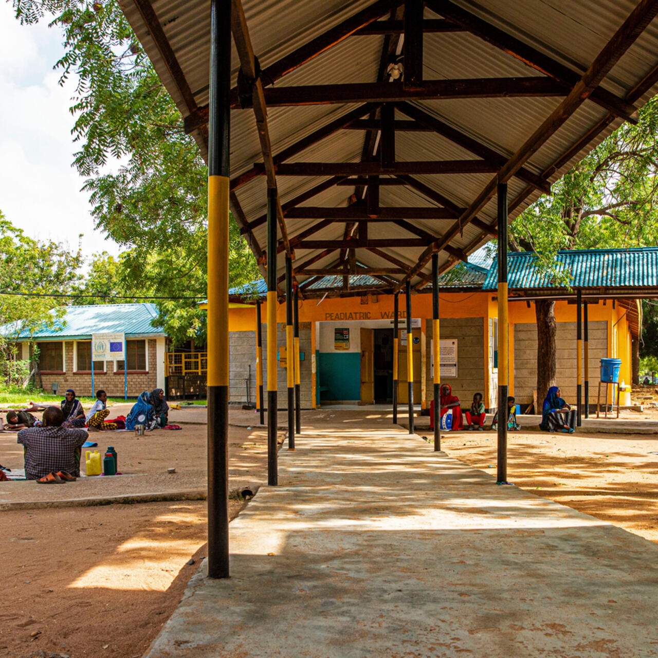 Patients sit with their families outside the pediatrics ward of the Hagadera Refugee Camp Hospital.